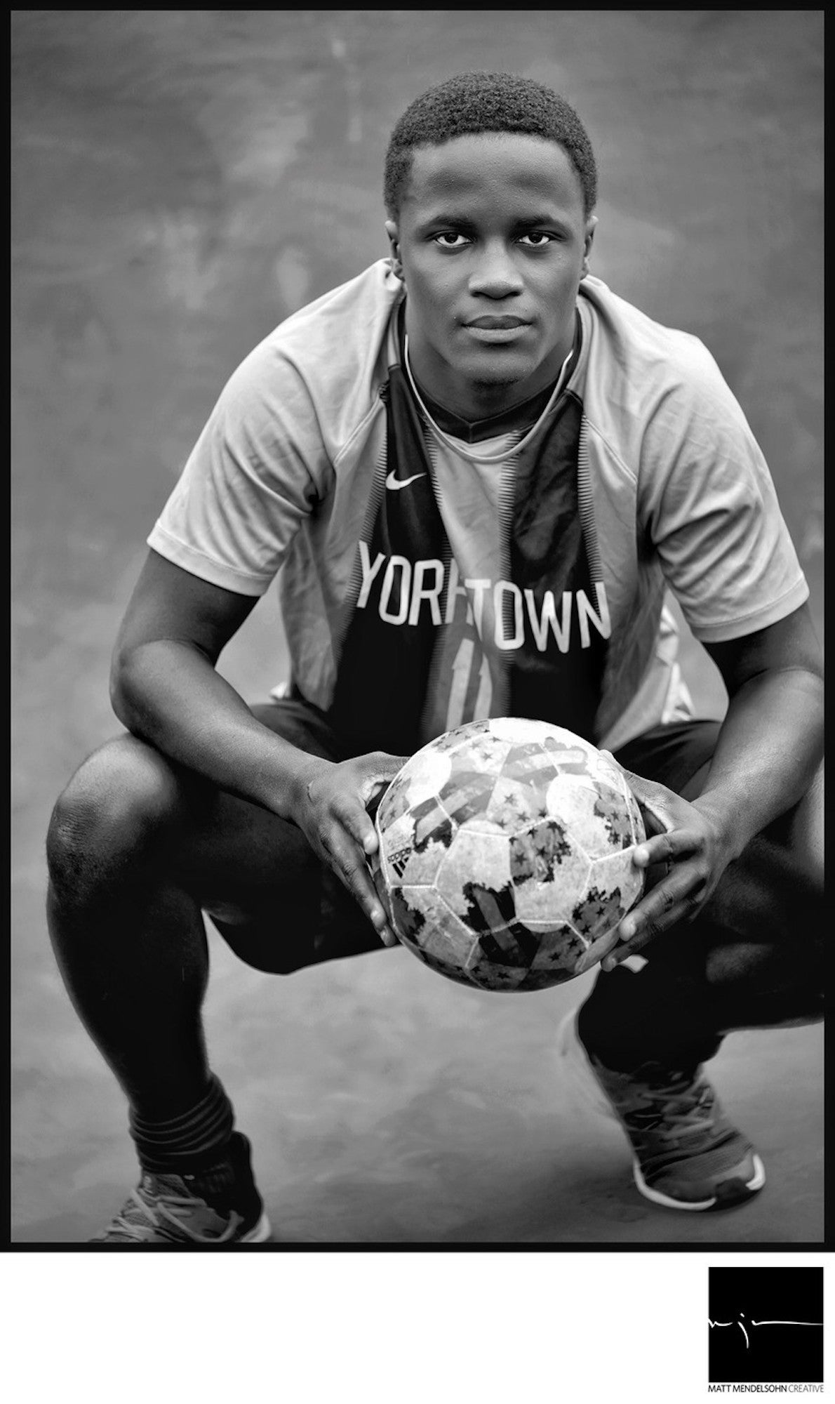 Alpha-Universe-Matt-Mendelsohn-senior-soccer-player-pius-kneeling-holding-soccer-ball.jpeg