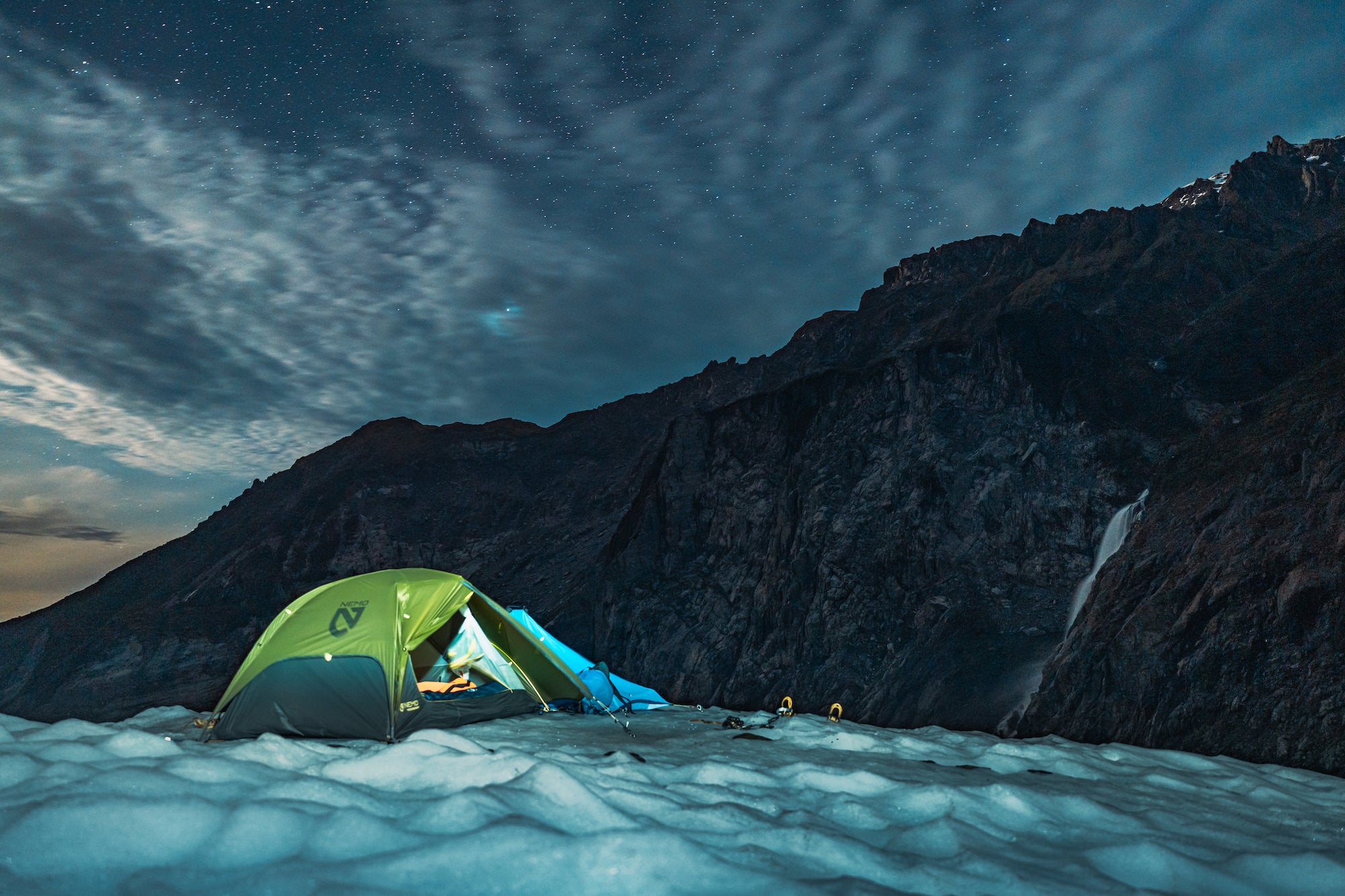 Green tent on icy mountain landscape