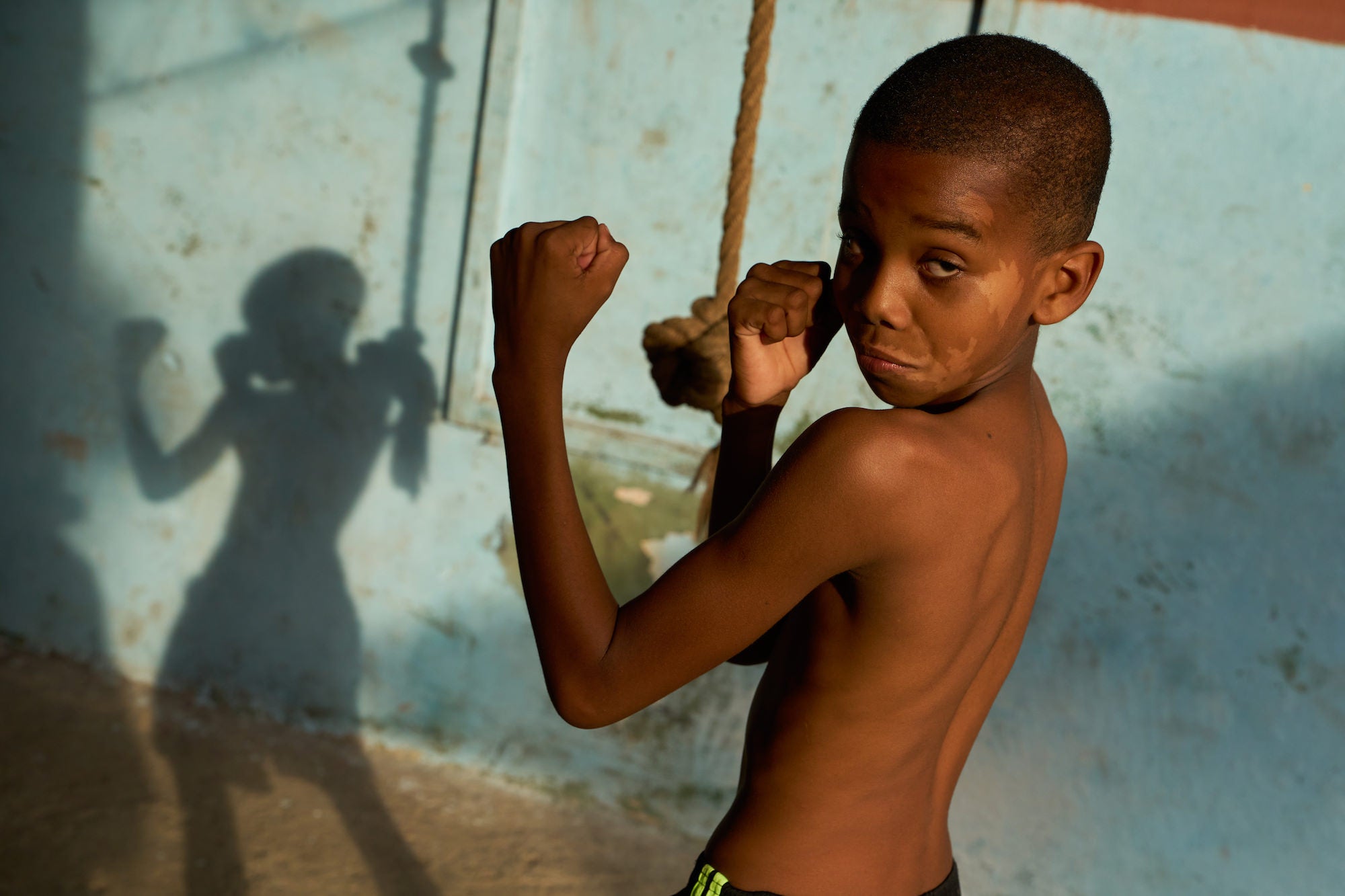 Young kid holding his fists up with shadow