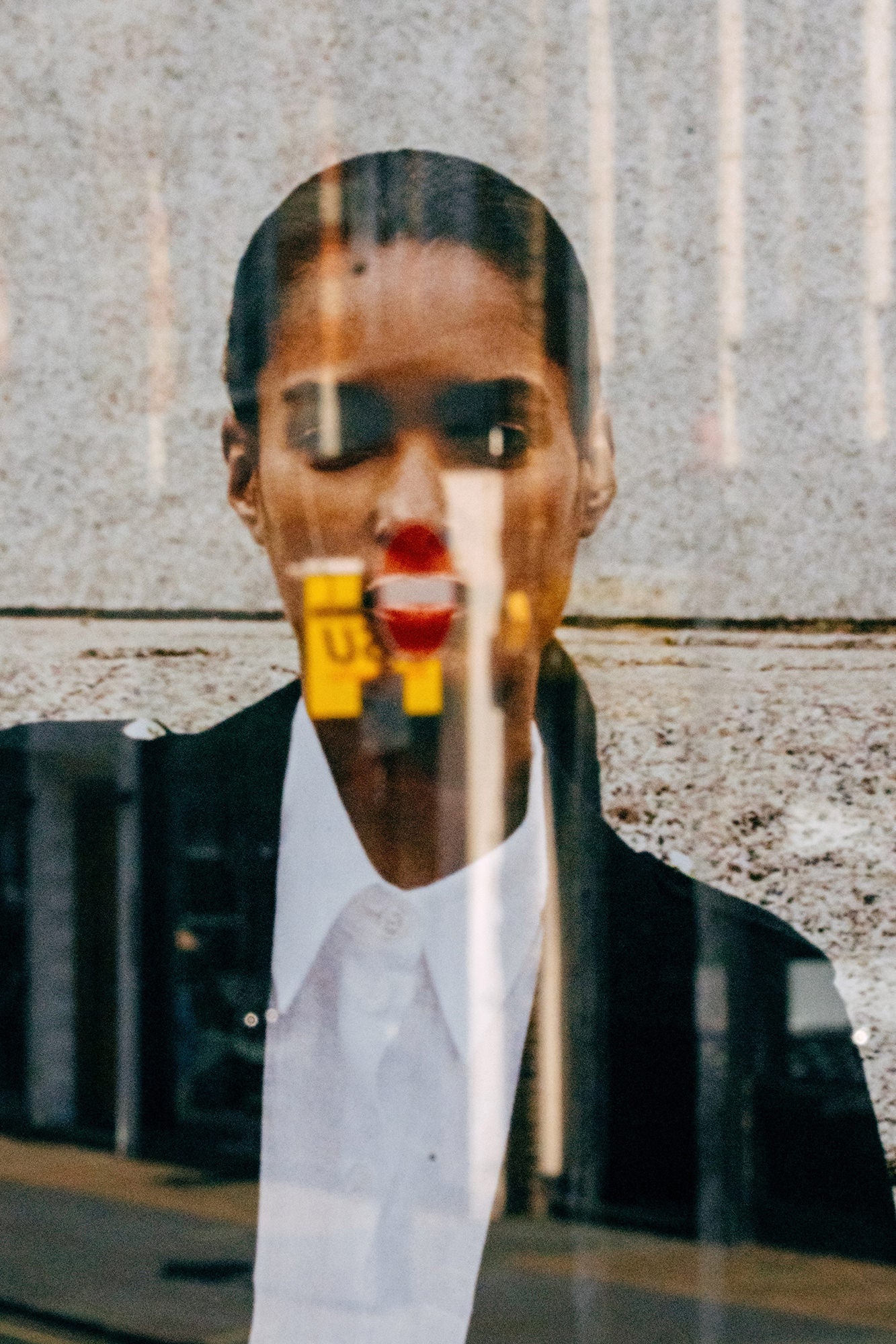 Abstract window reflection portrait with bold red lips in urban light, captured on Sony Alpha.