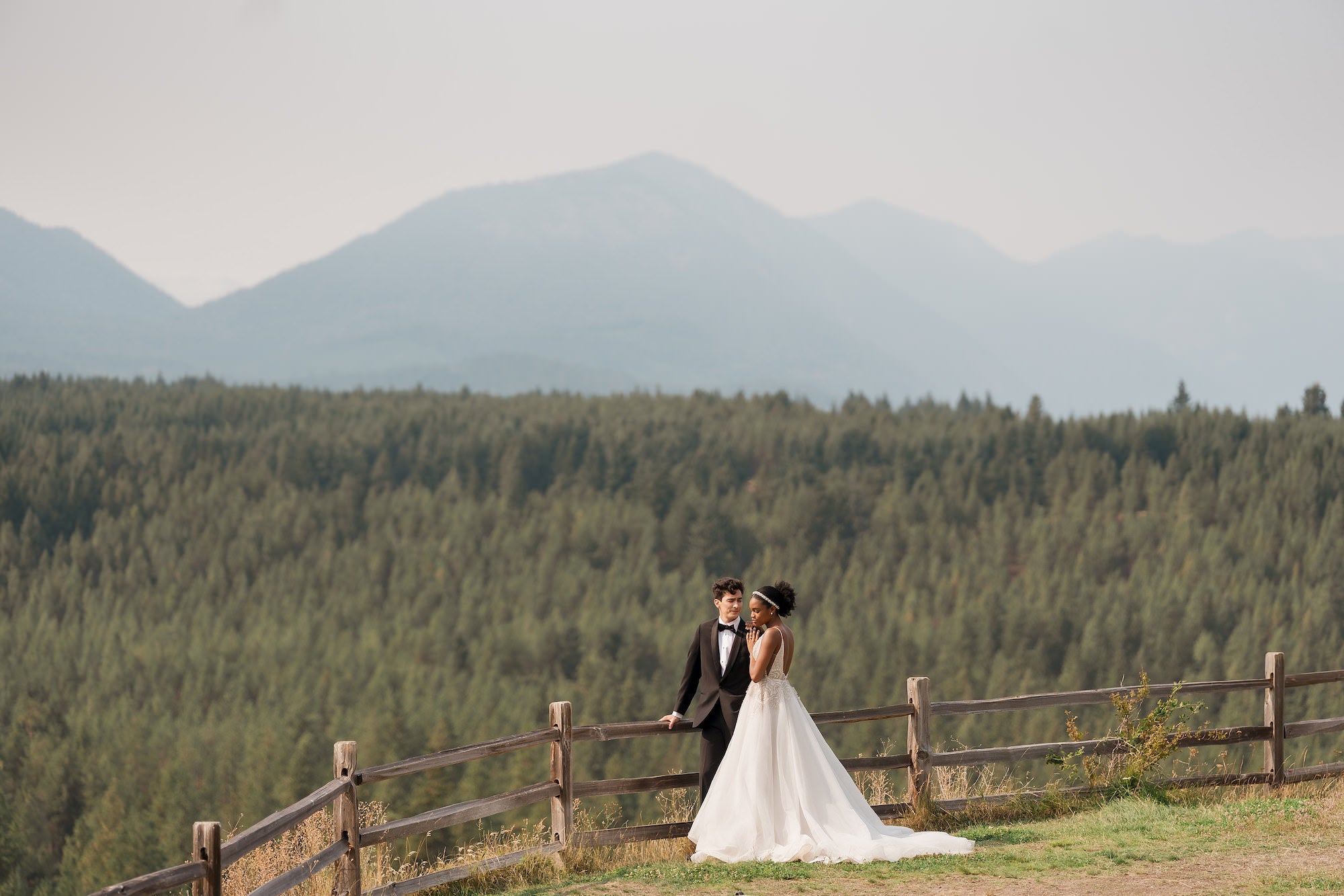 Bride and groom standing on path in front of sweet forest landscape Bride and groom standing on path in front of sweet forest landscape
