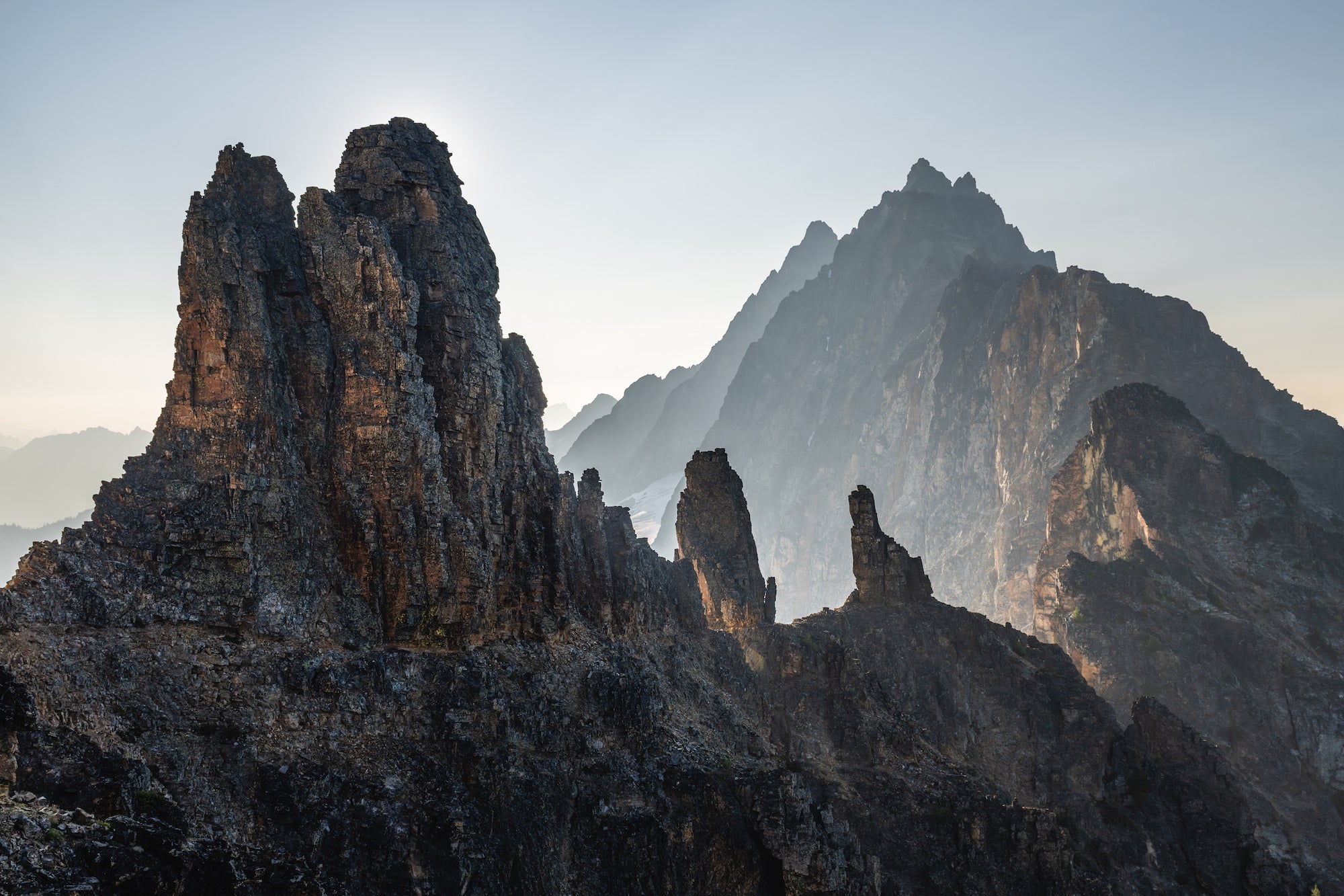 Rugged volcanic-like spires and layered ridgelines in backlight, revealing the craggy rock pinnacles of the North Cascades.