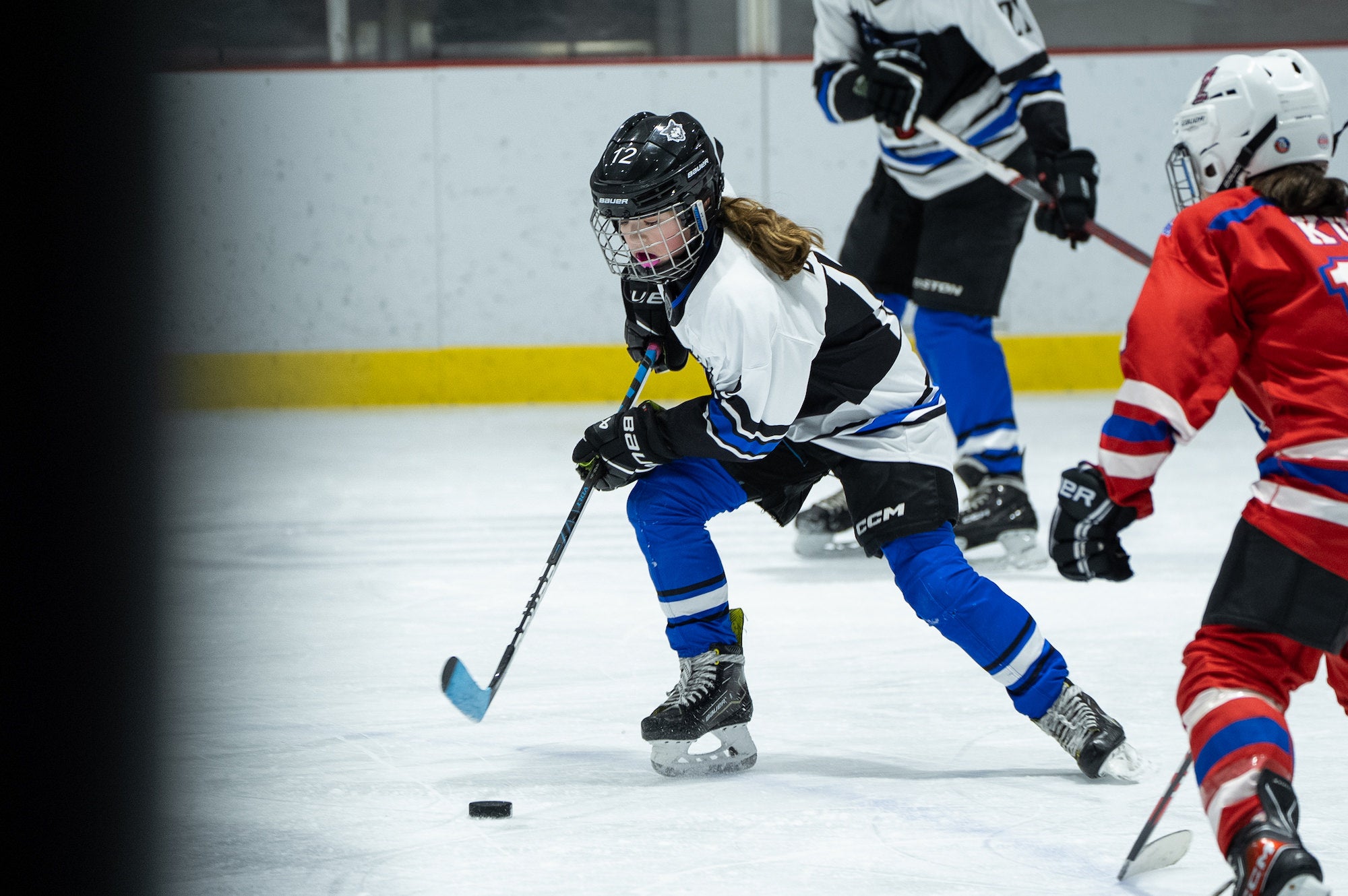 Youth hockey player skating down the ice with the puck.