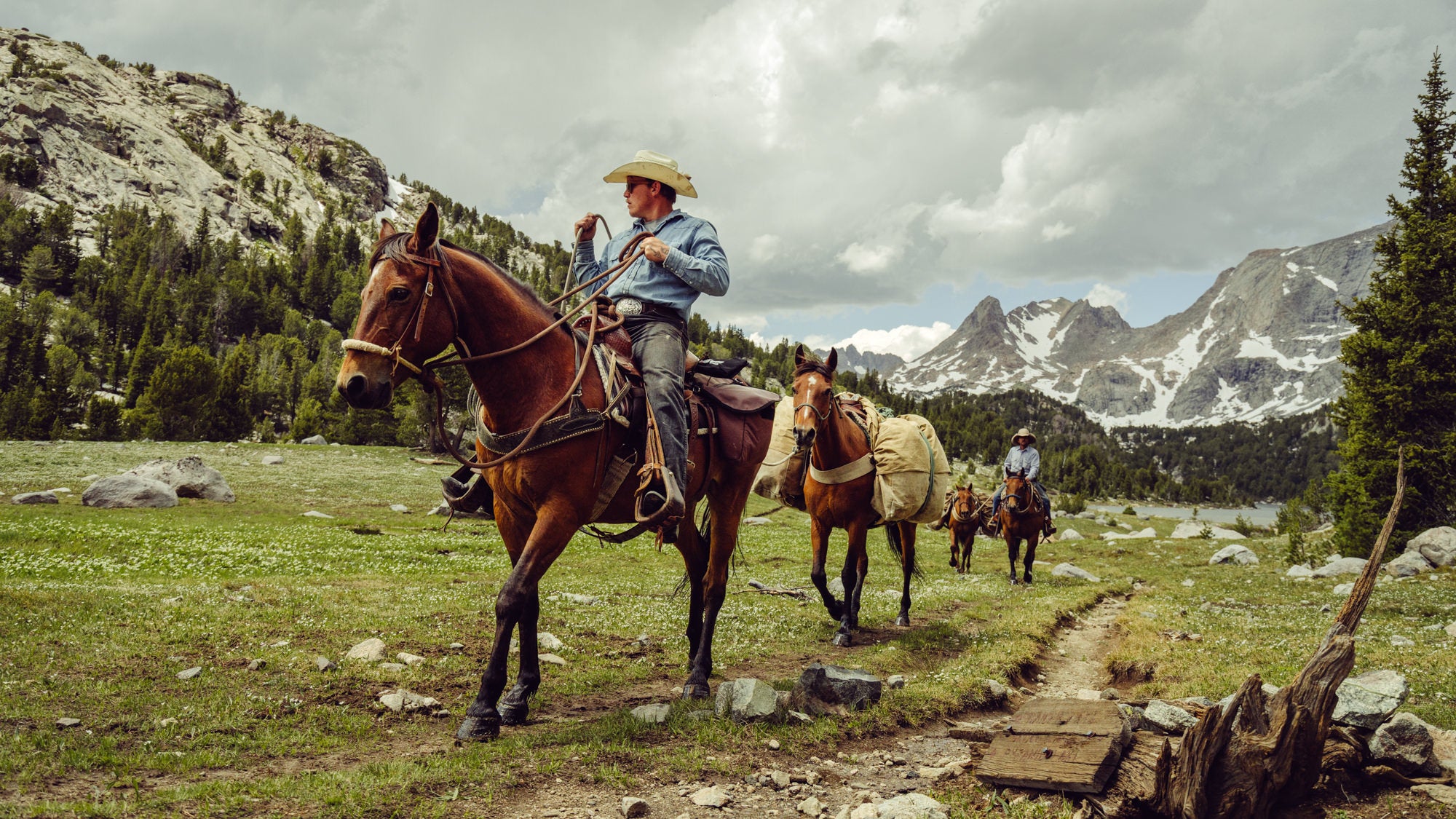 Cowboy on a horse going through the mountains.