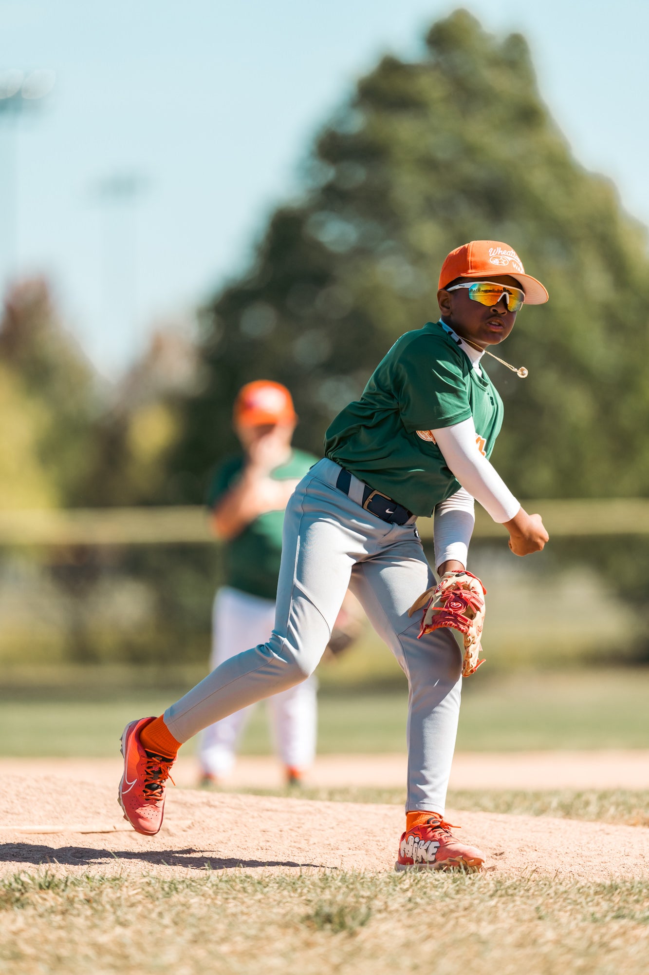 Pitcher follows through after the throw, glove hand low and body rotating toward home.