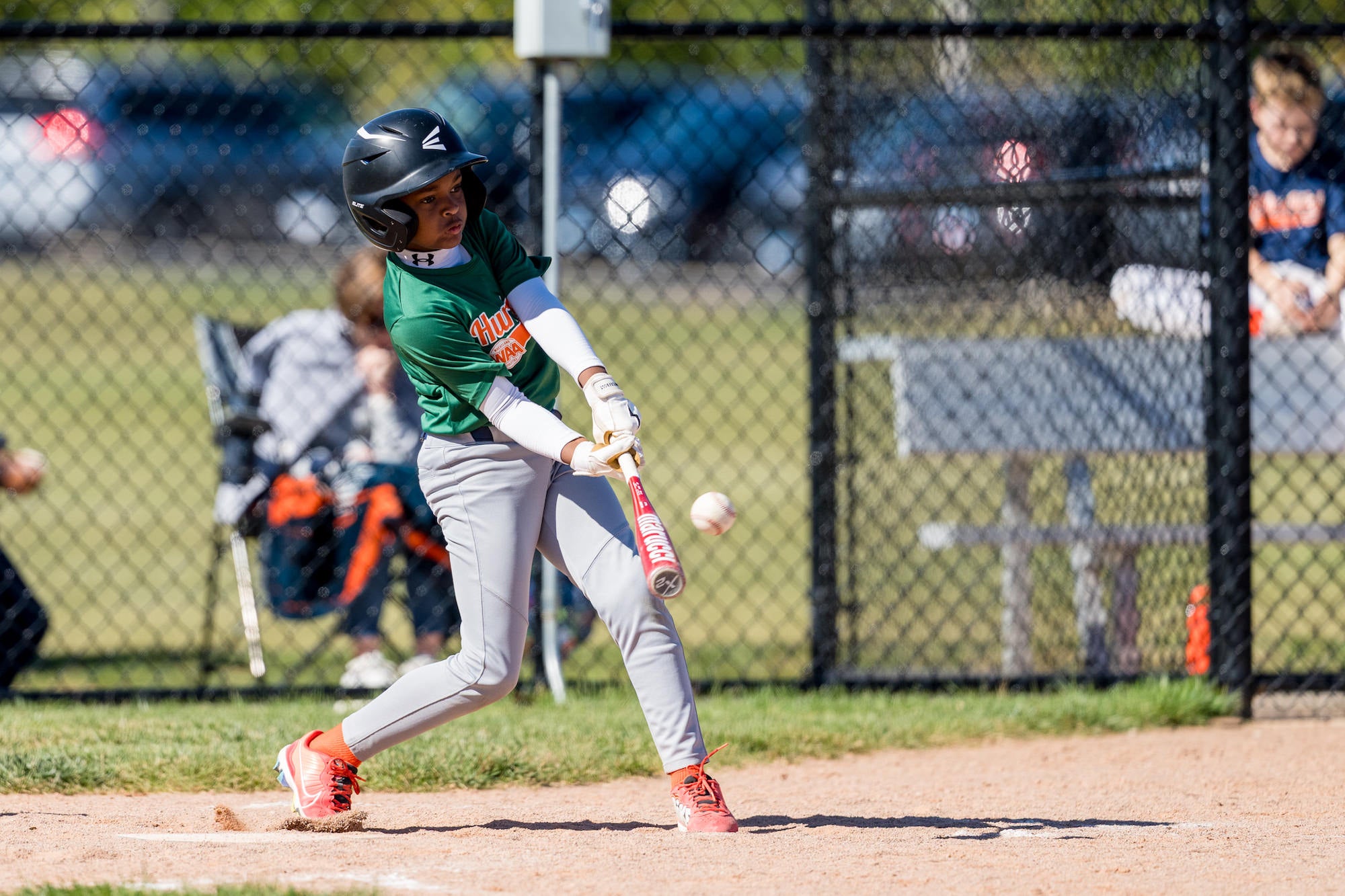 Batter drives the ball from the right side, bat flexing on contact, shallow depth of field.