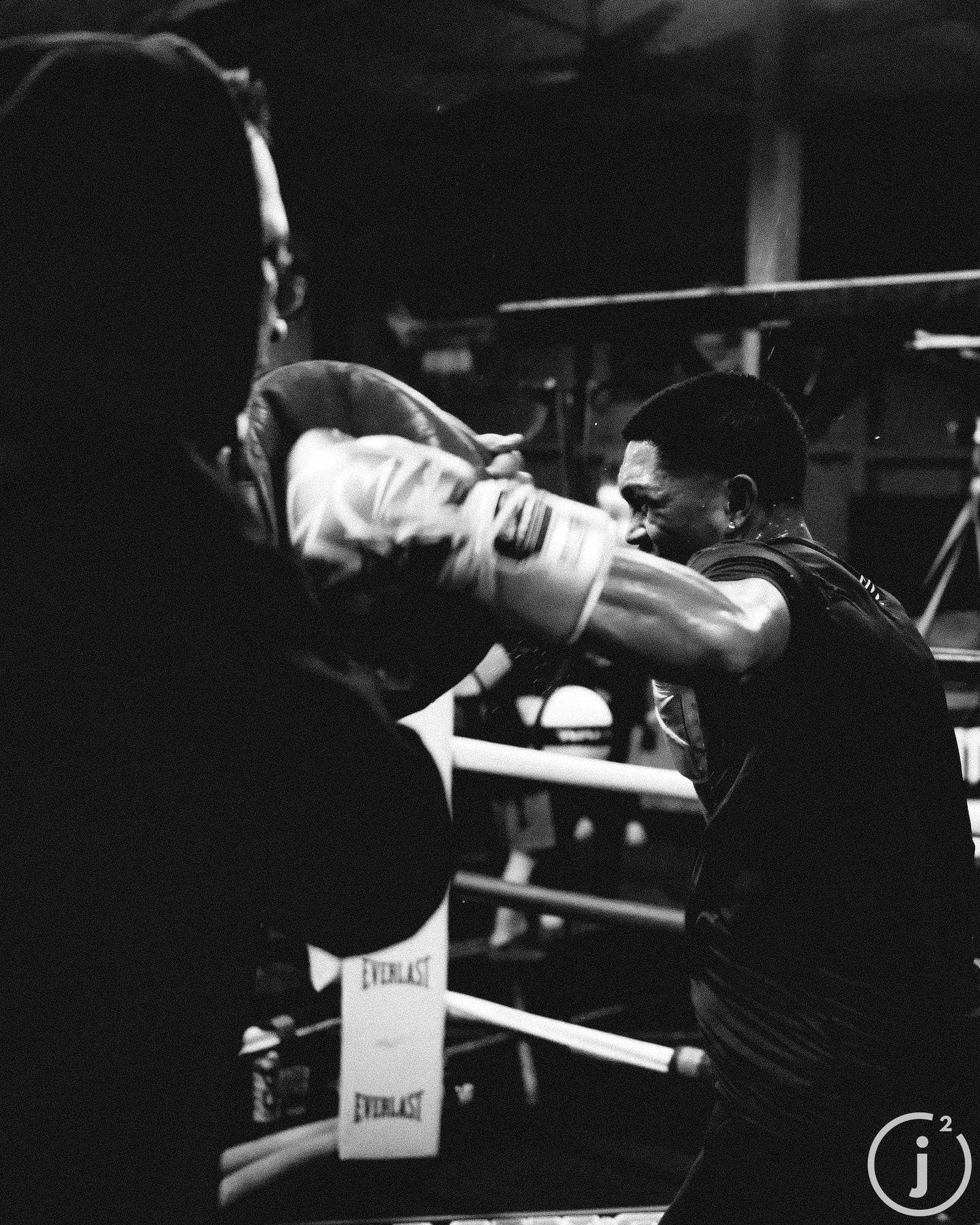 Boxer punching in the ring with trainer