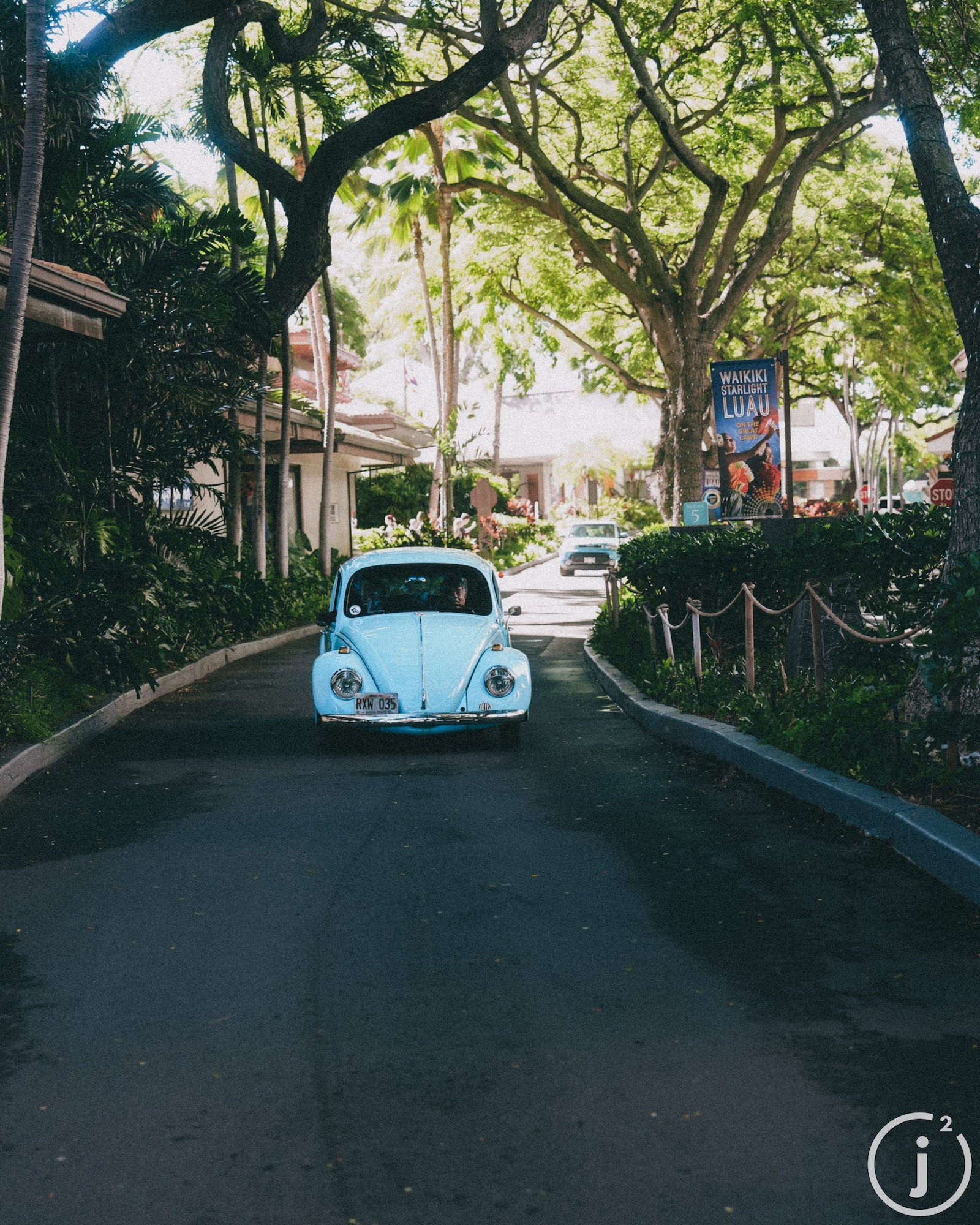 Teal Volkswagen beetle driving down the strees