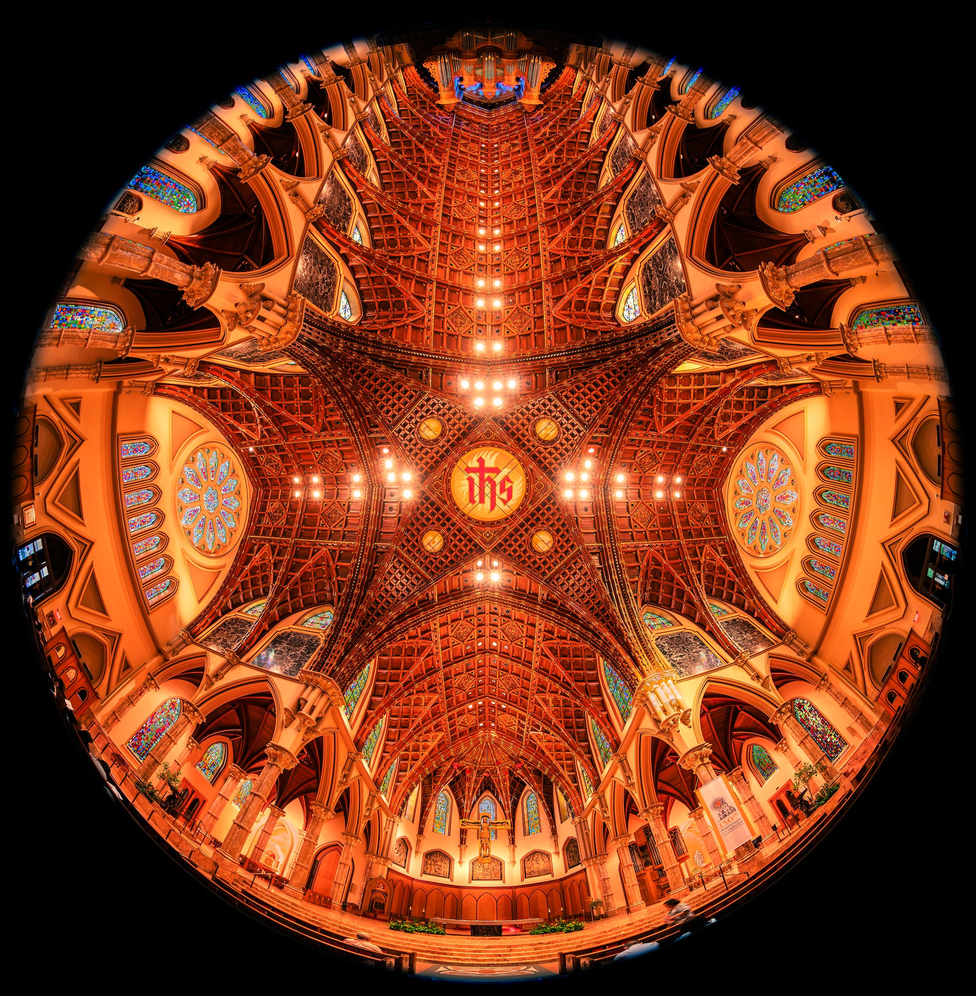 Ornate theater ceiling with glowing lights, stained glass and arched details above the stage. Photo by Mike Meyers. Alpha 1. 8-14mm f/3.5 Fisheye G. 1/20-sec. f/3.5. ISO 1000.