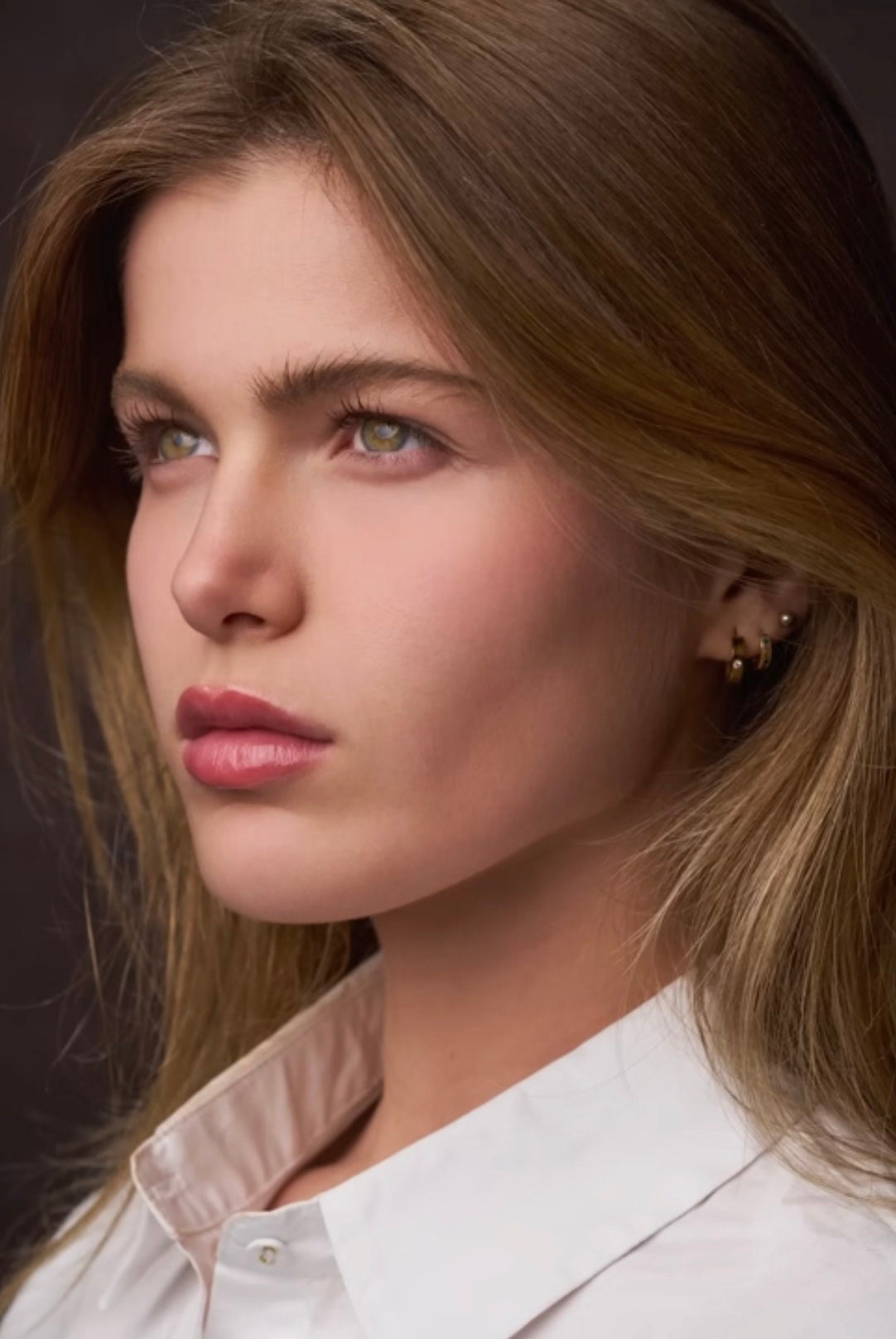 Close-up portrait of a blonde woman with a white collared shirt on