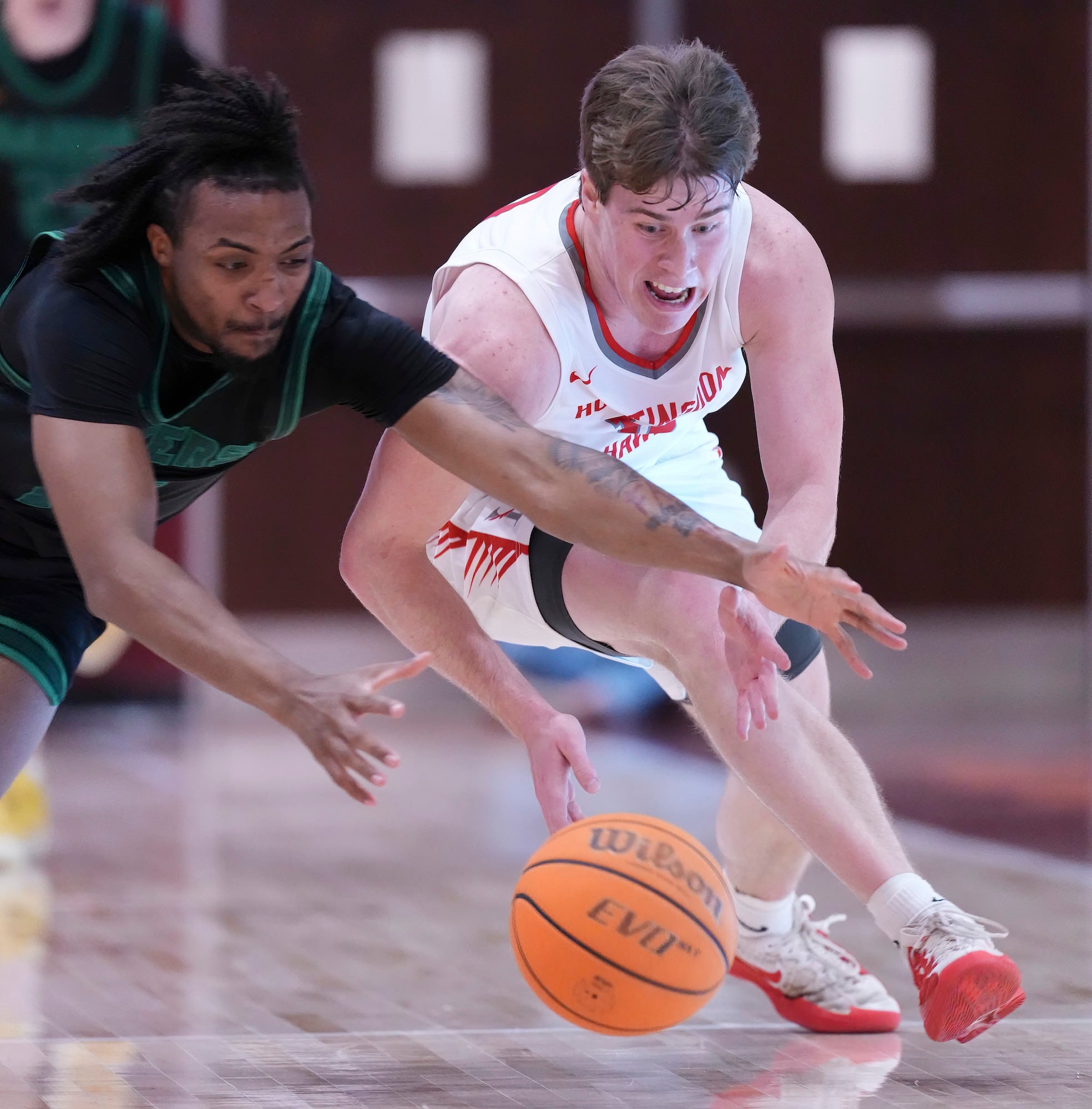 Close-up chase for a loose ball, two players reaching out