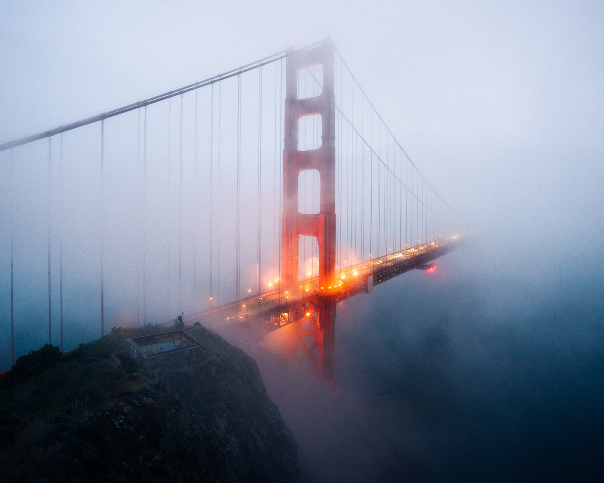 Golden Gate Bridge glowing through dense fog at blue hour, atmospheric San Francisco image by Paul Clark.