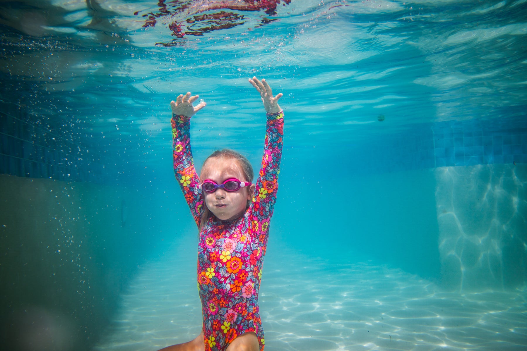 https://alphauniverseglobal.media.zestyio.com/underwater-girl-floral-rashguard-arms-up-bubbles.jpg?height=1200&fit=bounds